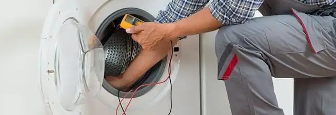 Dryer repair technician inspecting and repairing a clothes dryer in Boise, ID