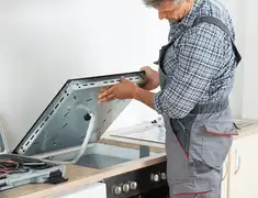 Appliance repair technician installing a built-in cooktop in Boise, ID