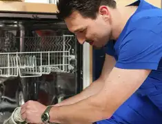 Dishwasher repair technician inspecting and servicing an open dishwasher in Boise, ID