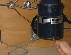 Garbage disposal repair technician tightening the mounting ring under a sink in Boise, ID