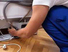 Appliance repair technician fixing refrigerator water line and connections in Boise, ID