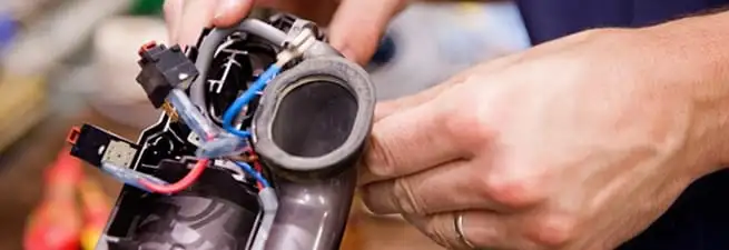 Vacuum repair technician reconnecting wiring and components in Boise, ID