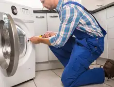Washing machine repair technician servicing a front-load washer in Boise, ID