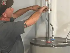 Water heater repair technician tightening supply line connections in Boise, ID