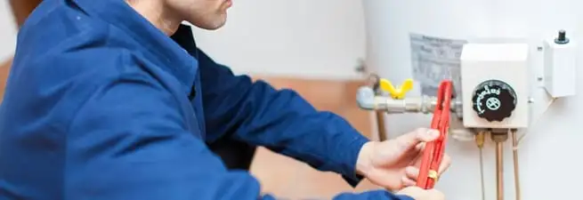 Water heater repair technician adjusting the temperature control and gas valve in Boise, ID